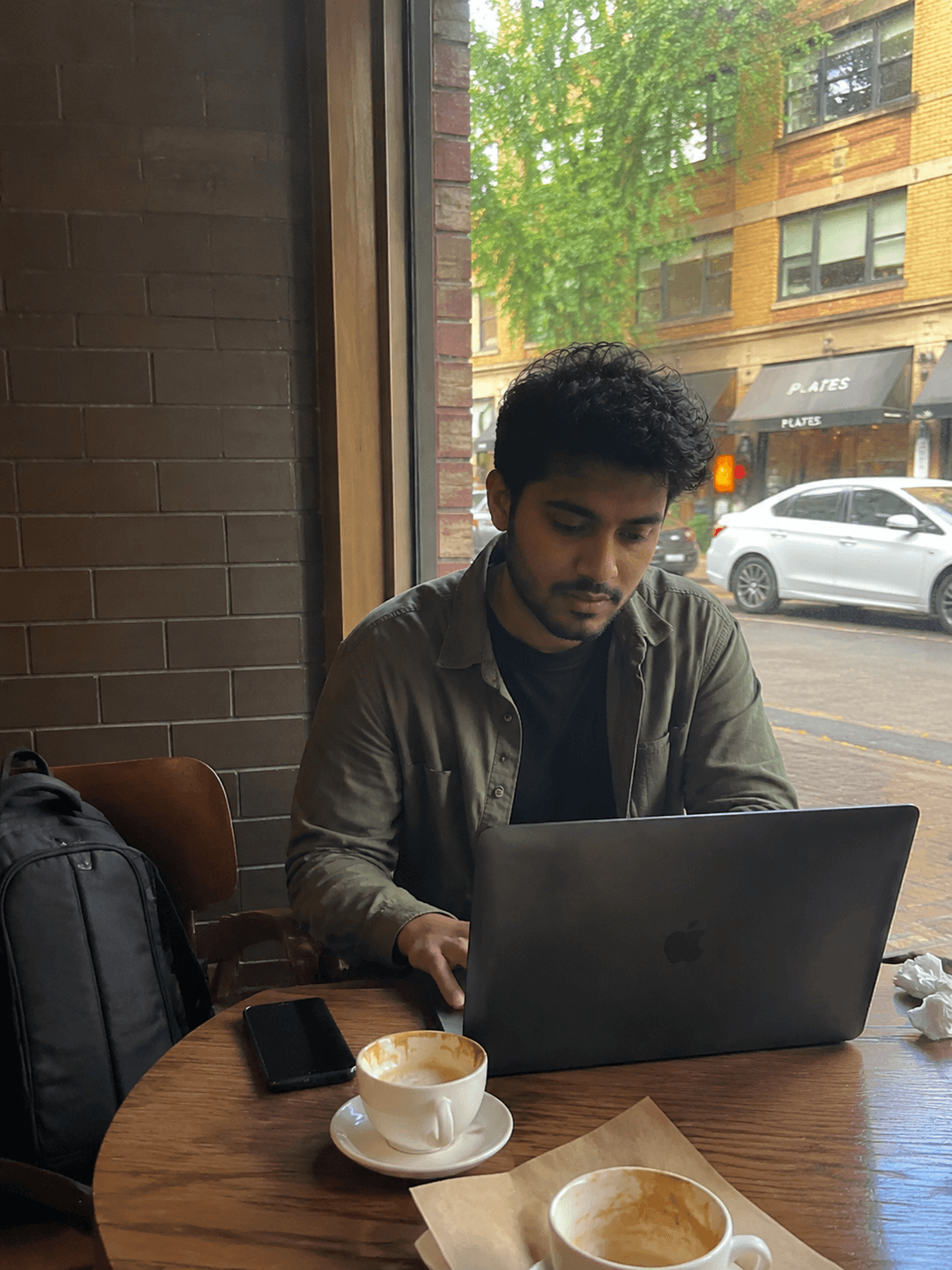 En terrasse avec un laptop, café crème, rue animée